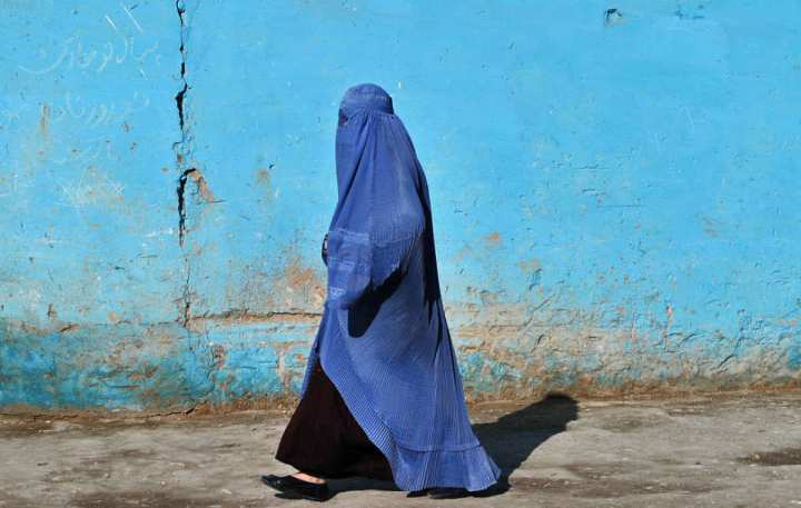 En människa, som bär burka, går på gatan. Vi kan inte se hennes ansikte.