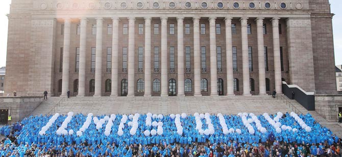 Demonstranterna använder ballonger för att bilda ordet Klimatlag i en demonstration framför parlamentshuset