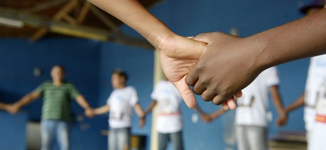 Ungdomar av olika hud färjer håller varandra i handen